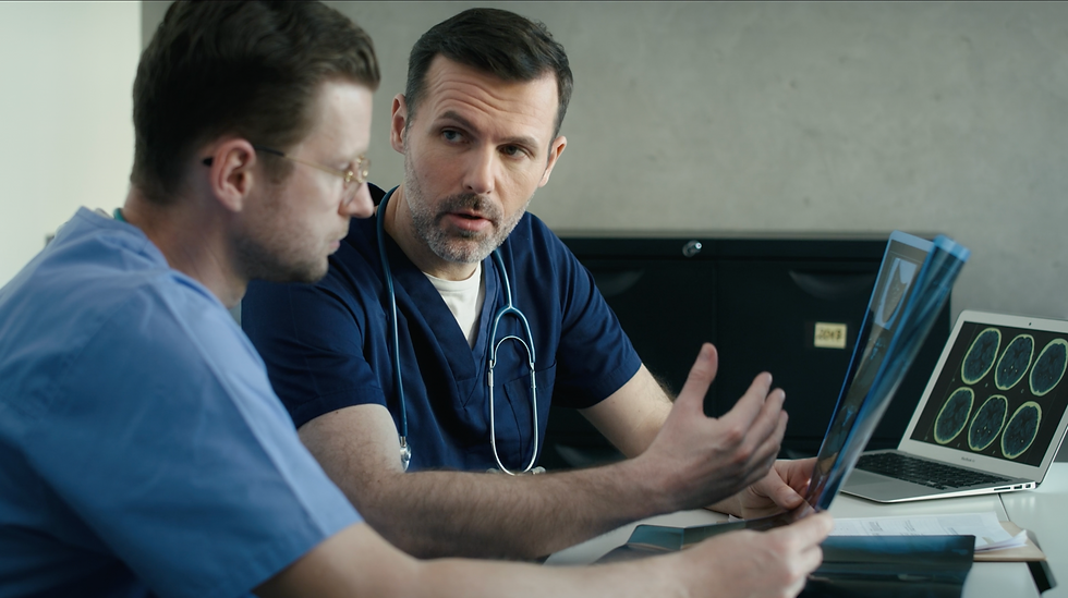 Two doctors collaborating while reviewing medical scans on a laptop. AI-assisted tools are helping healthcare professionals streamline workflows, enabling more efficient decision-making and reducing the administrative burden that leads to burnout.